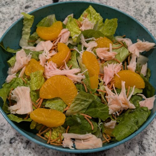 Freshly chopped Romaine Lettuce, topped with Mandarin Oranges, Costco Chicken, and Asian-style Crunchy Noodles.
