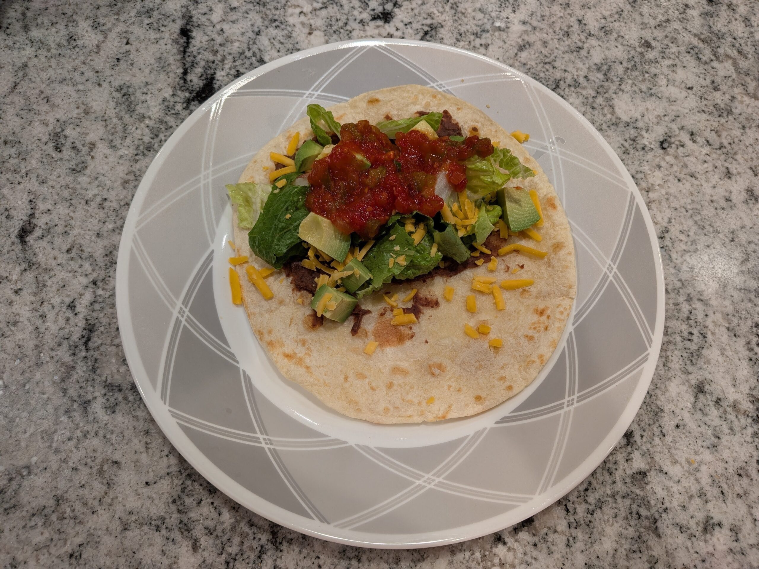 Flavored black beans wrapped in a warm freshly cooked tortilla topped with various toppings.