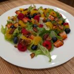 Crunchy lettuce topped with sweet and tangy berries mixed with mandarin oranges, and some candied almonds.