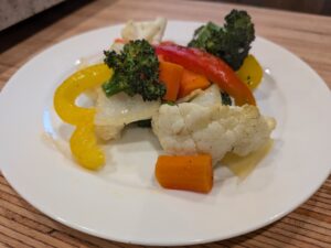 Colorful Veggies coated with oil, salt, pepper, and sprinkled with garlic salt. Roasted in the oven until tender and golden with a slight crisp.